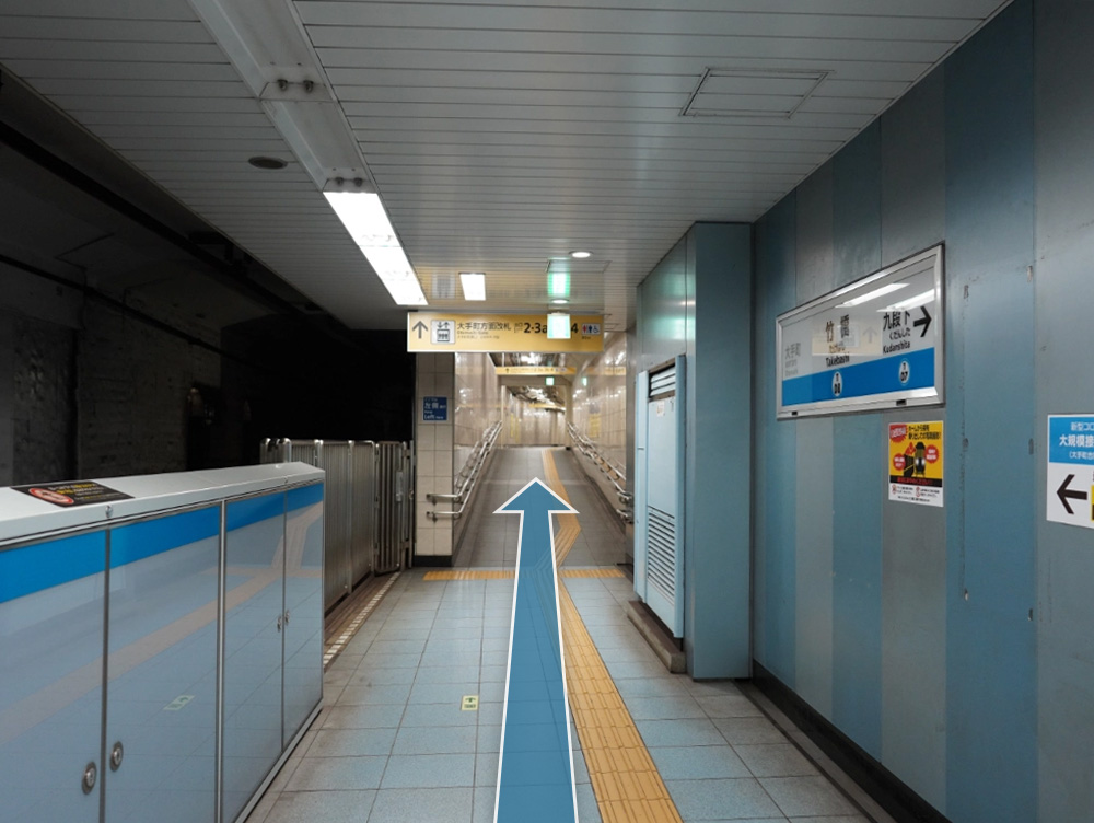 写真：東京メトロ東西線・竹橋駅ホーム （案内の看板に大手町方面改札、出口2・3a・3b・4、トイレ（男、女、車椅子）