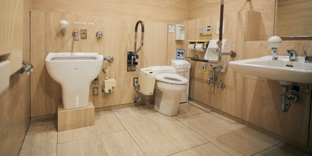 Photo : Equipment for ostomates (artificial anus and artificial bladder) and toilets with handrails are lined up, and there is a facility for folding diaper changing sheets in front.