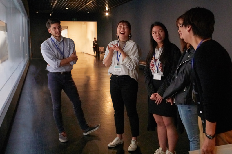 A facilitator and four people having conversation at the museum gallery.