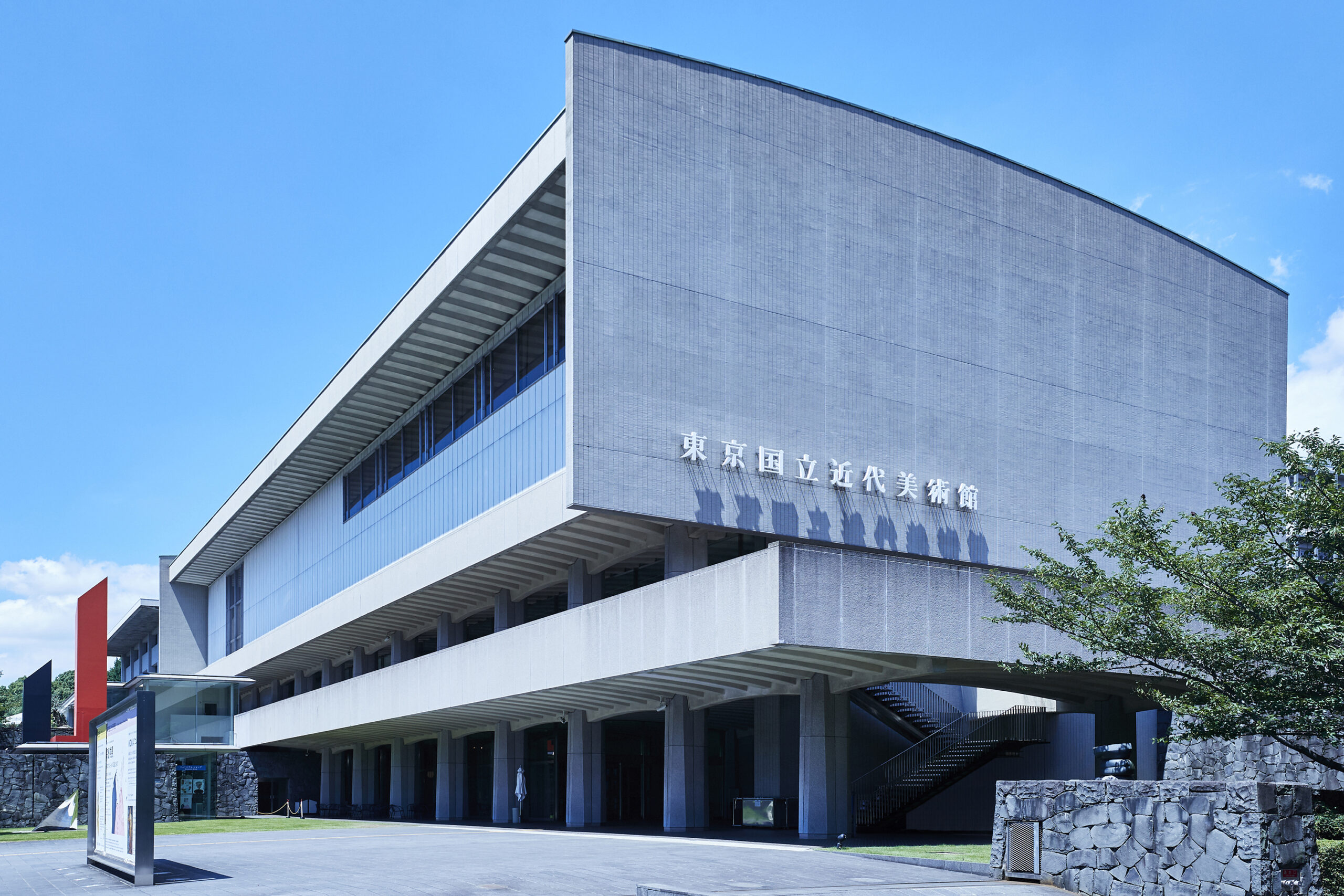 青空に美術館の建物、壁には東京国立近代美術館の文字が掲出されている