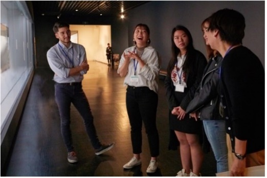 A facilitator and four people having conversation at the museum gallery.