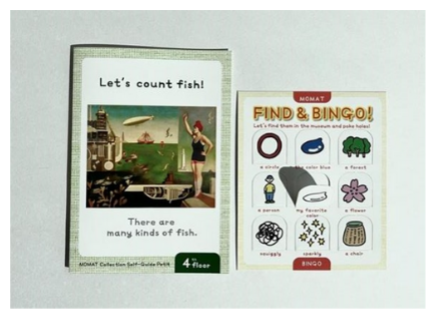 A pamphlet with a painting and a punch-out bingo card are placed together.