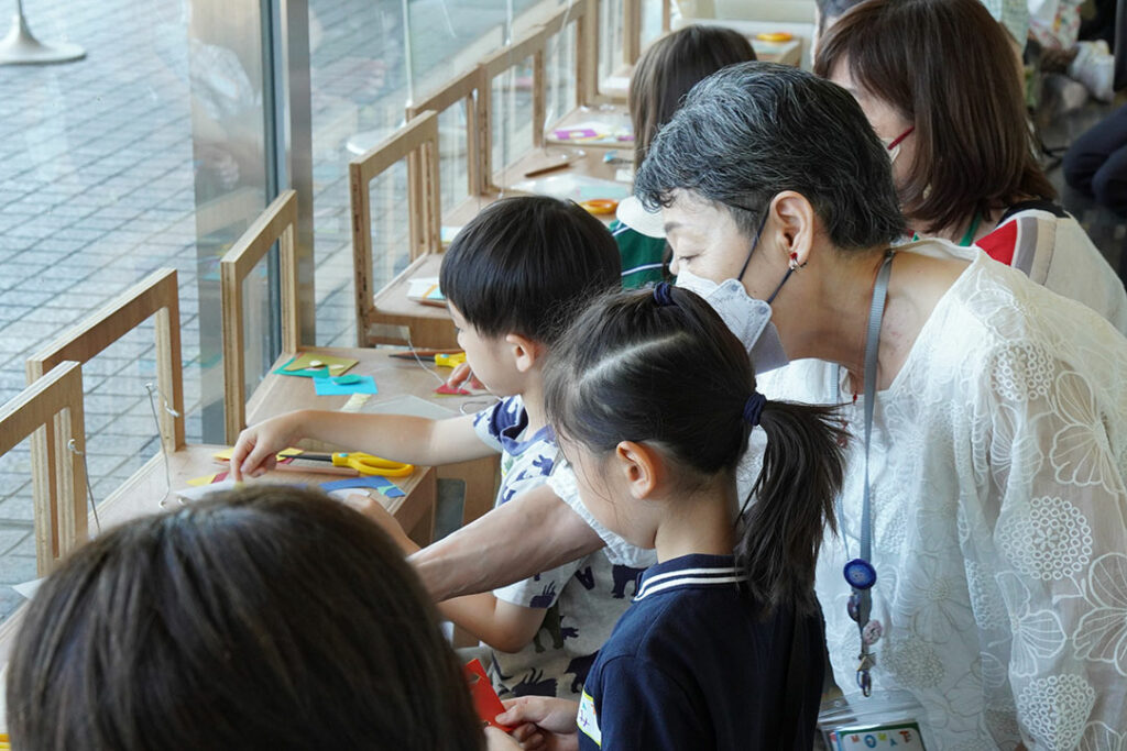 工作をする子どもたちとそれを教えるガイドスタッフ