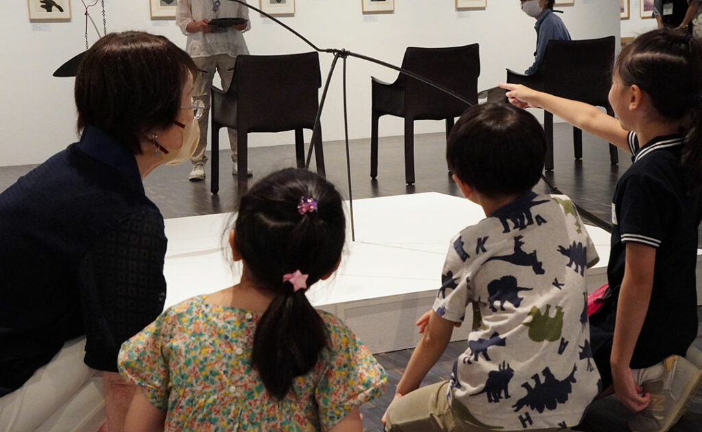 展示物を見るこどもたちとガイドスタッフ